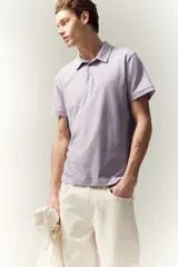 Remera polo lila de punto de algodón liviano, corte ajustado, manga corta, cuello clásico con tapeta de botones y bajo recto.