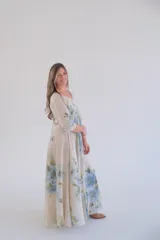 Vestido largo color beige con estampado de flores azules, corte amplio, escote en V y mangas 3/4.