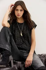 Remera negra de lentejuelas con calce relajado y cuello redondo.