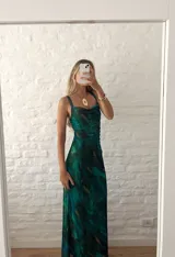 Vestido largo ajustado al cuerpo, confeccionado en microtul estampado con diseño abstracto en tonos verde, azul y marrón. Tiene breteles finos y forro interior opaco.