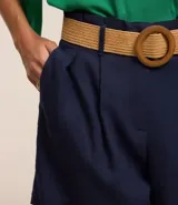 Short clochard azul marino de viscolino con trabillas en la cintura, cinturón con hebilla de madera y pliegues.
