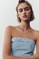 Top strapless de denim celeste con escote recto y cierre trasero con cremallera.