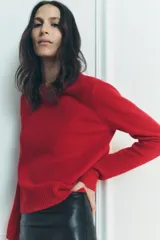 Jersey rojo de punto liso confeccionado en 100% lana. Tiene cuello redondo, manga larga y acabados en rib.