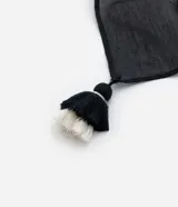 Pareo rectangular de chiffon con estampado de lunares en blanco y negro, con terminaciones de borlas.