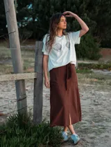 Falda midi marrón con lazo en la cintura, bolsillos laterales y tajo frontal.