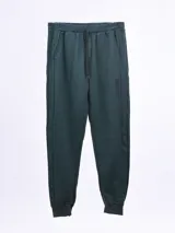 Pantalón de jogging verde oscuro con puños elásticos, bolsillos laterales y cordón ajustable en la cintura.