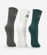 Kit de tres pares de medias de caña media New Balance, en colores gris, blanco y verde oscuro. Cada media tiene el logo de la marca bordado en el lateral.