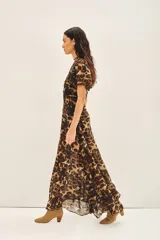 Vestido largo de viscosa georgette con estampado animal print de leopardo. Presenta escote en V, mangas amplias al codo, elástico y frunces en la cintura. Incluye un viso a tono con breteles regulables y puntilla en el escote.