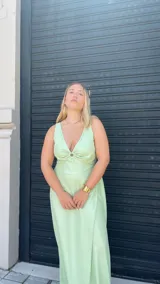 Vestido largo fucsia con escote en V con aro y falda en capas diagonales.