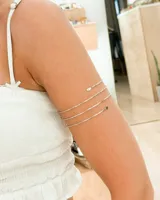 Brazalete plateado para el brazo, con cuatro aros finos y terminaciones redondeadas.