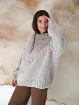 Sweater de lana gris con diseño de líneas y formas geométricas en color rosa.