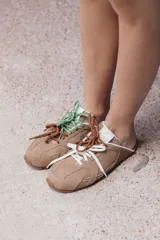 Zuecos color tostado de cuero con cordones de colores.