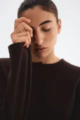 Blazer marrón entallado de punto interlock pesado con cuello redondo y botones forrados hasta la cintura creando un leve corte acampanado. Costuras princesa adelante y atrás para estilizar la silueta.