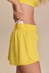 Pollera deportiva color verde lima, con short interno y bolsillo en la cintura.