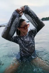 Vestido corto de lentejuelas negras translúcidas con mangas largas.