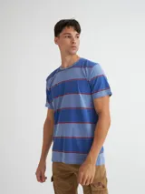 T-shirt de rayas en tonos azules y rojos, con etiqueta decorativa.