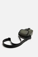 Bandolera vertical negra de acabado engomado con compartimento principal con cierre de cremallera y bolsillo interior plano. Bolsillo frontal con cierre de hebilla de liberación rápida. Asa de hombro ajustable y extraíble.