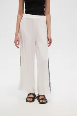 Pantalón blanco de viscosa, corte ancho y tiro alto, con detalle de bordado calado negro en los laterales.