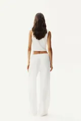 Pantalón recto blanco de punto con textura arrugada, cintura elástica y cordón ajustable.
