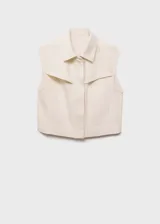 Chaleco color crema de denim con cuello camisero, cierre frontal con botones ocultos, sin mangas y corte recto.