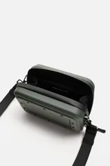 Bandolera rígida negra con formato de caja. Tiene un compartimento principal con cierre de cremallera, un bolsillo interior plano y asa de hombro ajustable y extraíble.