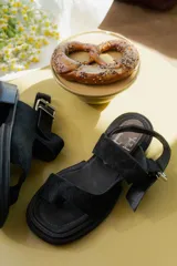 Sandalias negras con plataforma y dos tiras de pelo sintético.