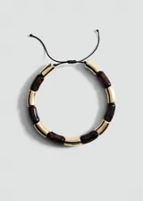 Collar corto con cuentas tubulares de resina color carey alternadas con cuentas doradas, engarzadas en hilo negro con cierre corredizo ajustable.
