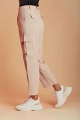 Pantalón color beige, de corte recto, con bolsillos laterales tipo cargo y bolsillos traseros con solapa.