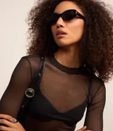 Blusa de tul transparente color negro, con cuello alto y mangas largas.