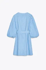 Vestido corto celeste con bordados calados, escote en V, mangas 3/4 abullonadas con elástico y cinturón con hebilla redonda de madera. Cierre frontal con botones.