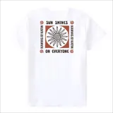 Remera blanca de manga corta con cuello redondo y un pequeño estampado cuadrado en el pecho. El estampado presenta un diseño circular con rayos y texto en tonos rojos y marrones.