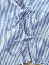 Conjunto de short y top a rayas azules y blancas. El top es sin mangas y tiene lazos en la parte delantera. El short tiene cintura elástica.