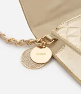 Bolso transversal pequeño color dorado, con correa de cadena y colgante redondo. Textura capitoneada, efecto metalizado y separador interior con cierre.