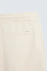 Bermuda de algodón color marrón oscuro, de corte regular fit, con cintura elástica ajustable mediante cordón. Presenta bolsillos laterales y un bolsillo trasero de vivo.