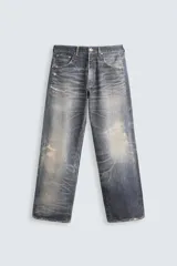 Pantalón de jean azul con lavado gastado, corte holgado y cinco bolsillos.