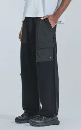 Pantalón jogger negro con múltiples bolsillos, botamanga regulable y cintura elastizada. Confeccionado en algodón combinado con microfibra y calce relaxed fit.