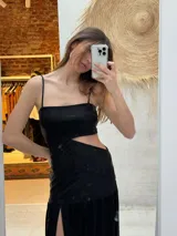Vestido largo negro con cortes asimétricos y frunces, diseñado por Isa Berruti.