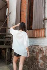 Blusa blanca de mangas cortas con volados, escote en V y lazo de ajuste.