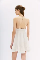 Vestido corto blanco de algodón con breteles finos, escote en V con detalle de bordado calado, espalda baja con elástico y volados en el ruedo.