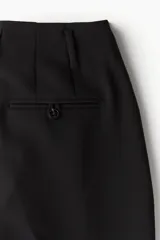 Pantalón de vestir negro con pinzas, corte recto y bolsillos laterales.