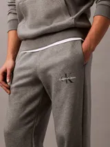 Pantalón de jogging gris con cintura elástica, bolsillos laterales y logo de Calvin Klein Jeans en la pierna. Confeccionado en mezcla de algodón y poliéster.
