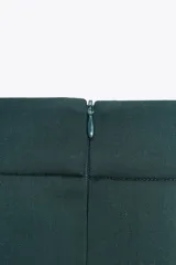 Falda midi verde oscuro con tablas, de tiro alto y cierre trasero con cremallera oculta.