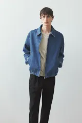 Pantalón de vestir negro con pliegues, corte recto y bolsillos laterales.