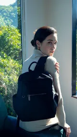 Mochila verde militar de nylon con apertura superior con cierre y tiradores metálicos. Incluye bolsillos internos, bolsillo con cierre metálico al frente, correa corta de mano y correas de galón regulables para colgar en la espalda.