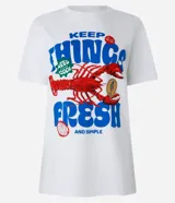 Remera blanca de algodón con corte alargado, cuello redondo y mangas cortas. Estampa frontal con una langosta y la frase "Keep Things Fresh".