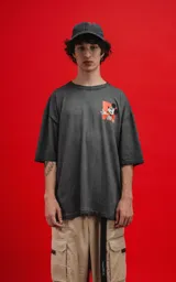 Remera de algodón premium, color gris oscuro con efecto lavado, corte oversize y manga corta. Presenta un pequeño estampado frontal de Mickey Mouse en un recuadro naranja.