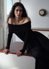 Vestido largo negro de tejido fluido con hombros descubiertos y mangas largas.