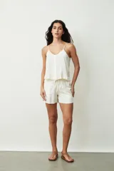 Short negro de tiro alto con cordón ajustable en la cintura y bolsillos laterales. Presenta un corte holgado y ruedos redondeados.