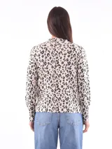 Sweater color beige con estampado de leopardo, cuello redondo y mangas largas.