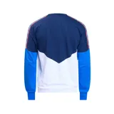 Buzo de frisa azul marino, blanco y celeste con cuello redondo, puños y cintura acanalados. Presenta el logo de Umbro bordado en blanco en el pecho izquierdo, el escudo del Club Nacional de Football bordado en el pecho derecho y una cinta con diseño geométrico en los hombros.